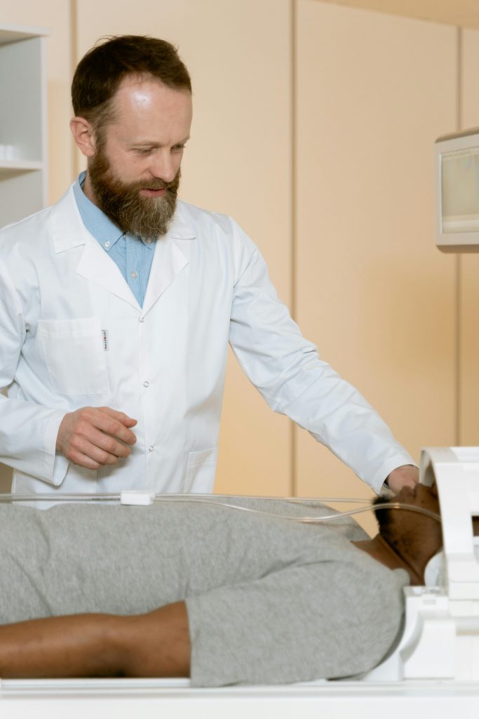 Doctor overseeing a CT scan procedure on a patient in a hospital setting.